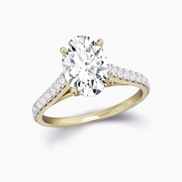 Our Rue Cler Setting is a diamond band solitaire engagement ring shown here with an oval cut diamond in 18ct yellow gold